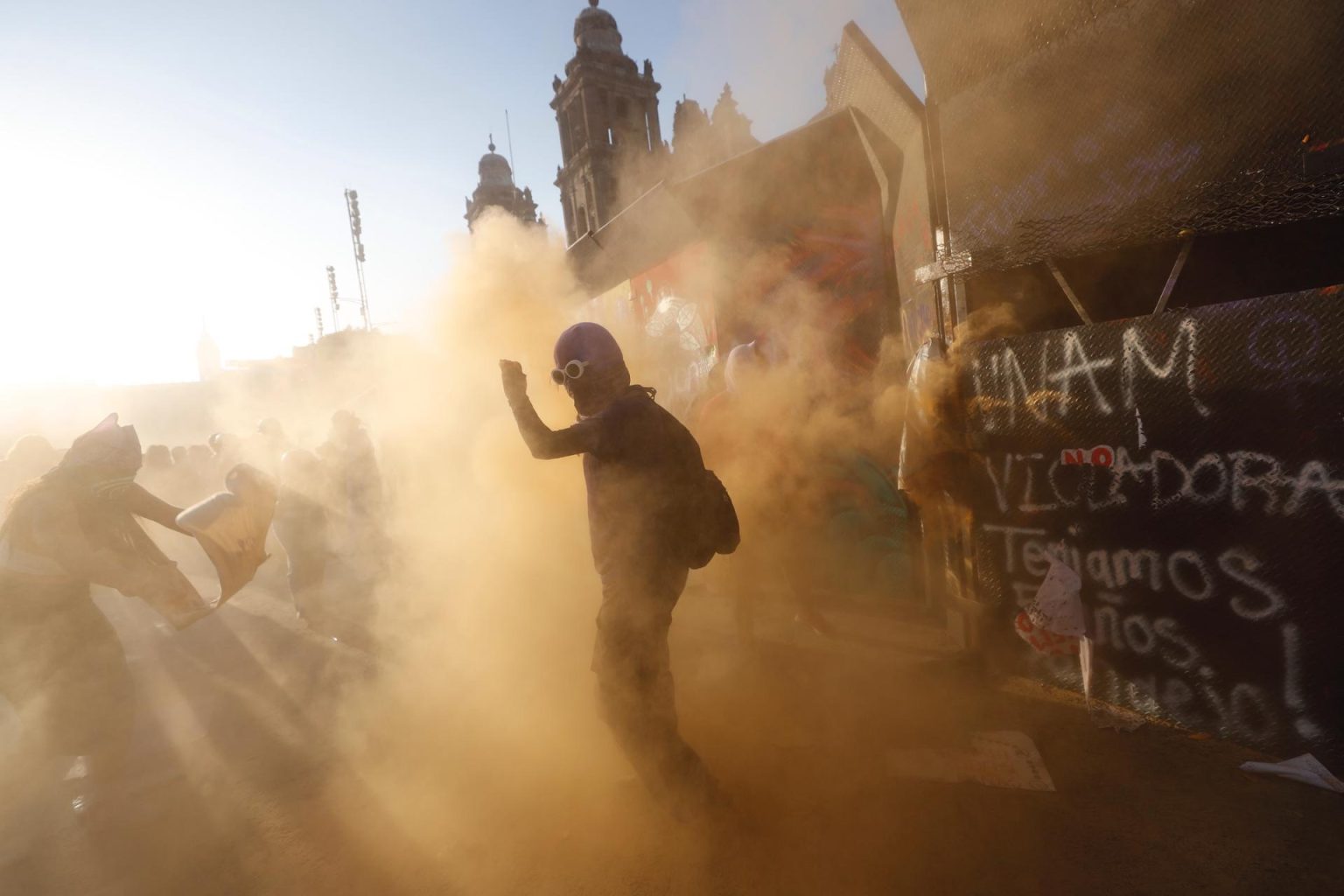 Una mujer es vista donde otras intentan derribar una valla de acero durante una marcha con motivo del Día Internacional de la Mujer, este viernes en Ciudad de México (México). EFE/Sáshenka Gutiérrez