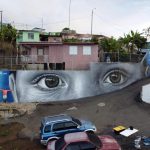 Fotografía cedida por la organización 'Arte para Unir' donde aparece el artista español Diego As (i) mientras posa junto a su mural que forma parte del proyecto 'Miradas del barrio', realizado en el barrio de El Cerro, en Yauco (Puerto Rico). EFE/Arte para Unir /SOLO USO EDITORIAL /NO VENTAS /SOLO DISPONIBLE PARA ILUSTRAR LA NOTICIA QUE ACOMPAÑA /CRÉDITO OBLIGATORIO