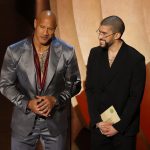 Dwayne Johnson (i) y Bad Bunny (d) durante la ceremonia de los premios Oscar. EFE/EPA/CAROLINE BREHMAN