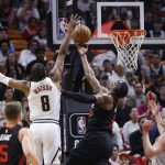 Peyton Watson (2i), alero de los Nuggets de Denver, fue registrado este miércoles, 13 de marzo, al intentar bloquear el ataque Bam Adebayo, ala-pívot de los Heat de Miami, durante un partido de la NBA, en el coliseo Kaseya Center, en Miami (Florida, EE.UU.). EFERhona Wise