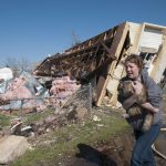 Una mujer lleva un gato que ha rescatado entre los daños provocados por un tornado. Imagen de archivo. EFE/Nick Oxford