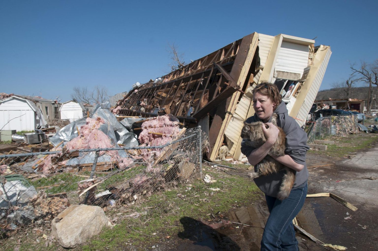 Una mujer lleva un gato que ha rescatado entre los daños provocados por un tornado. Imagen de archivo. EFE/Nick Oxford