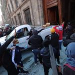 Manifestantes encapuchados vandalizan una de las puertas del Palacio Nacional este miércoles, en Ciudad de México (México). EFE/ Madla Hartz