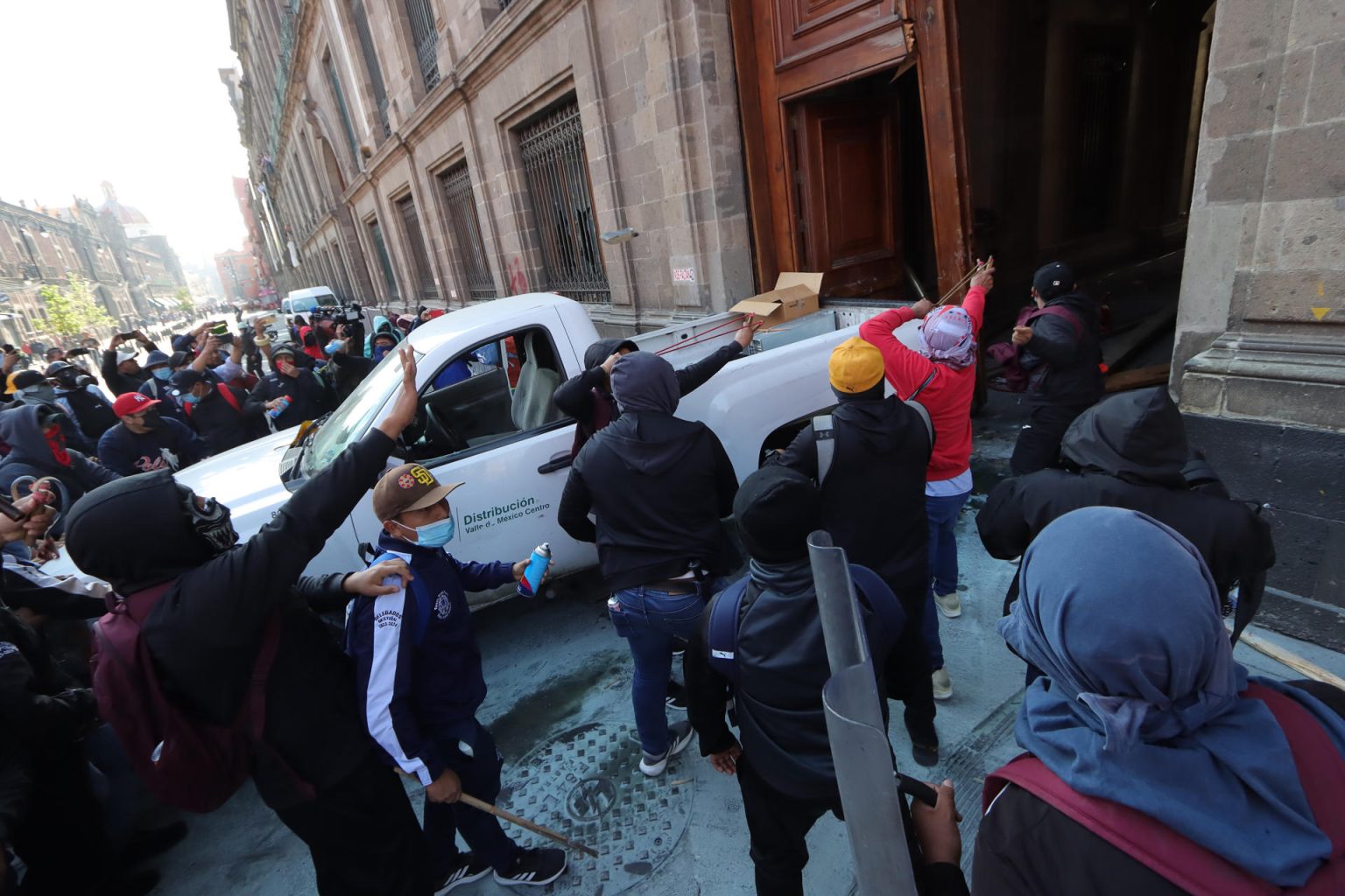 Manifestantes encapuchados vandalizan una de las puertas del Palacio Nacional este miércoles, en Ciudad de México (México). EFE/ Madla Hartz