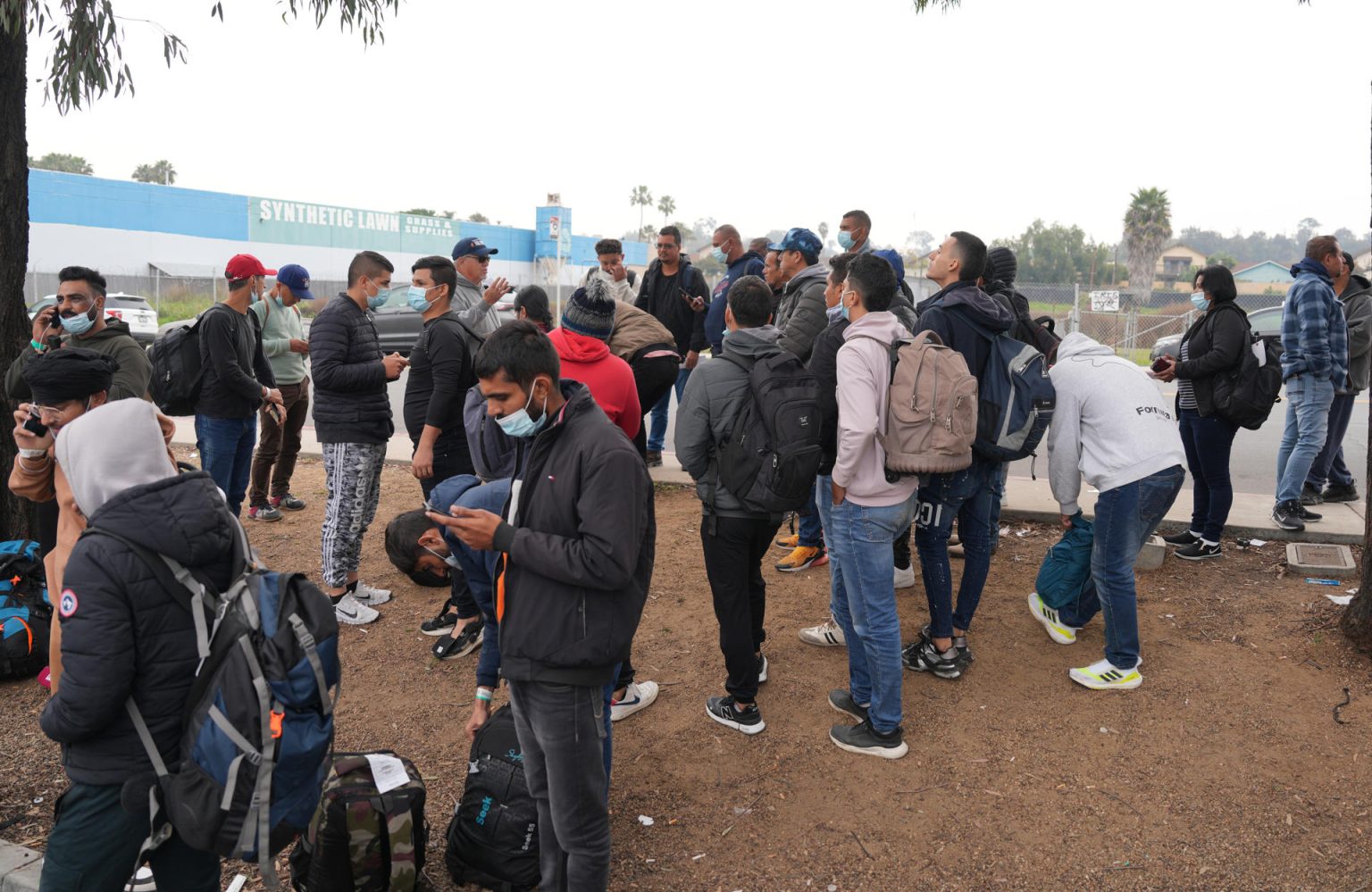 Un grupo de migrantes liberados por la Patrulla Fronteriza esperan un autobús en San Diego, California (EE.UU.). EFE/ Manuel Ocaño