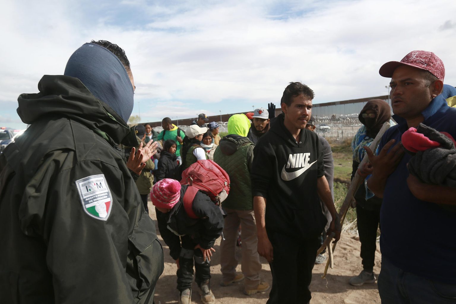 Personal del Instituto Nacional de Migración (INM) y un grupo de migrantes dialogan tras una trifulca este martes, en las inmediaciones de la frontera con Estados Unidos, en Ciudad Juárez (México). EFE/Luis Torres