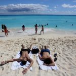 Fotografía fechada el 1 de febrero de 2024, que muestra turistas mientras descansan en una playa, del balneario de Cancún, en Quintana Roo (México). EFE/Alonso Cupul