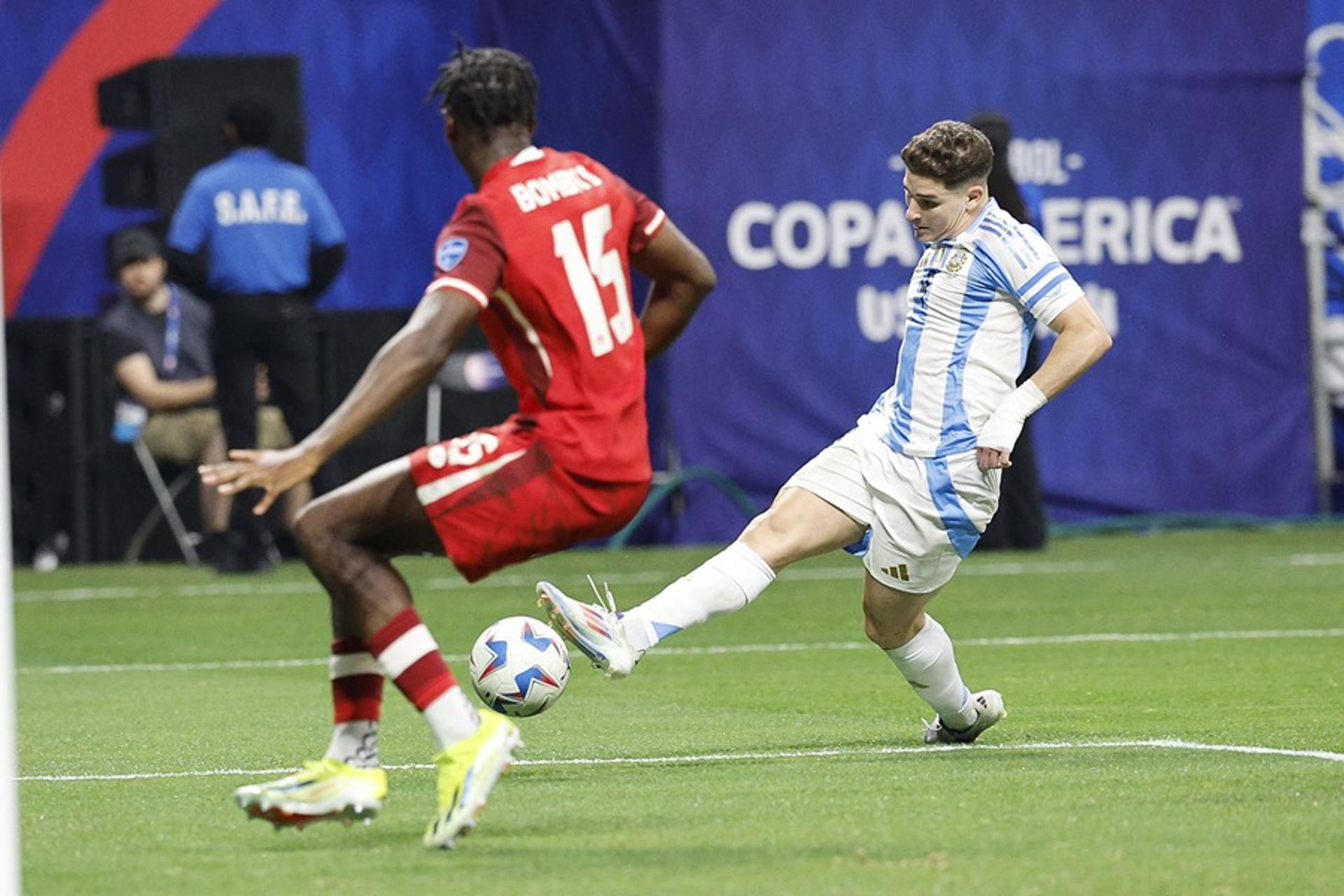 Fotografía de archivo, tomada el pasado 20 de junio, en la que se registró al delantero argentino Julián Álvarez (d), al intentar superar la marca del defensor canadiense Moise Bombito (i), durante el partido inaugural de la Copa América 2024, en el estadio Mercedes Benz de Atlanta (Georgia, EE.UU.). Bombito fue víctima de insultos raciales a través de Instagram, luego de este partido. EFE/Erik S. Lesser
