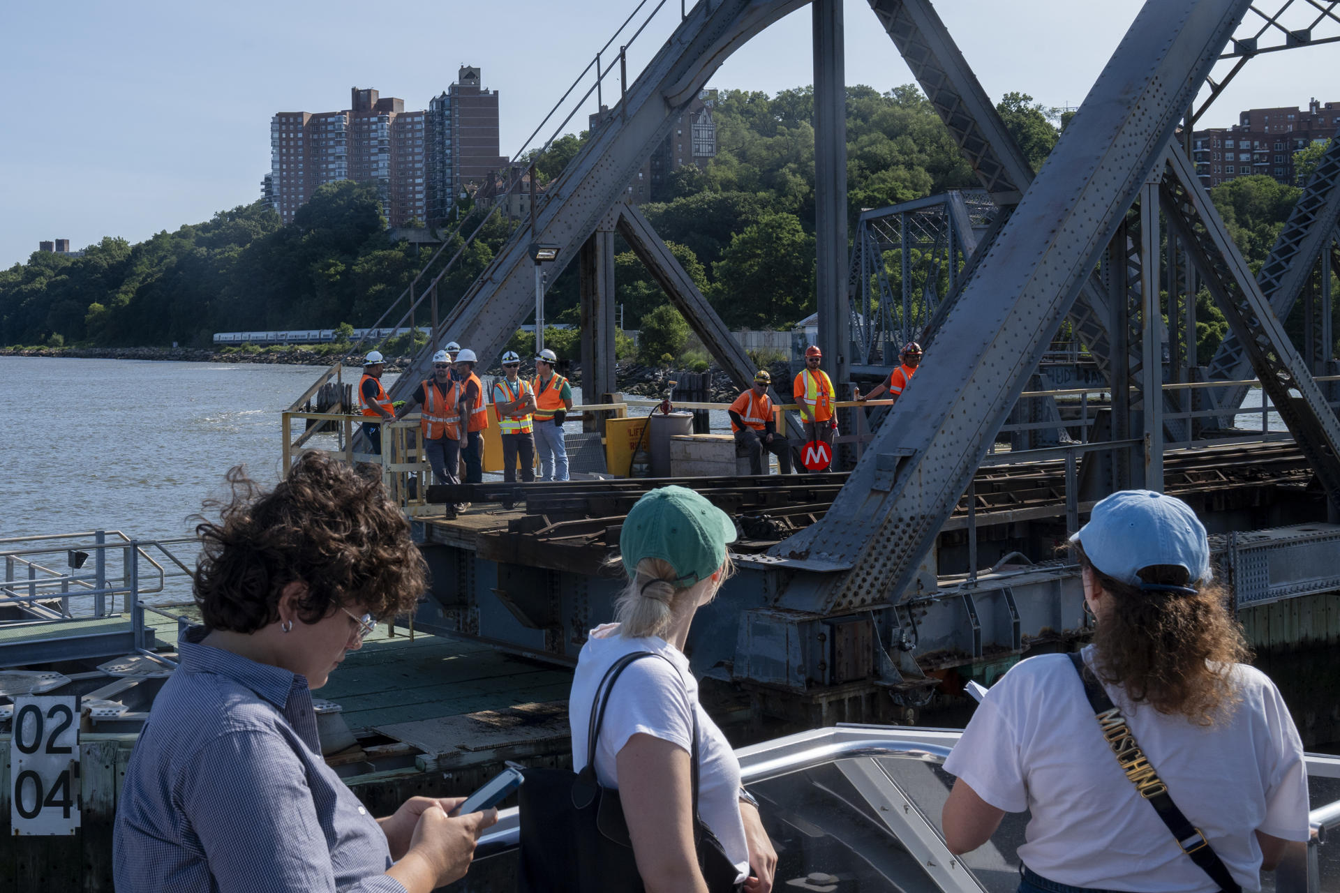 Personas observan a unos trabajarodes durante el tour anual en barco por la justicia ambiental este viernes, en el río Harlem, Nueva York (EE. UU.). EFE/Ángel Colmenares
