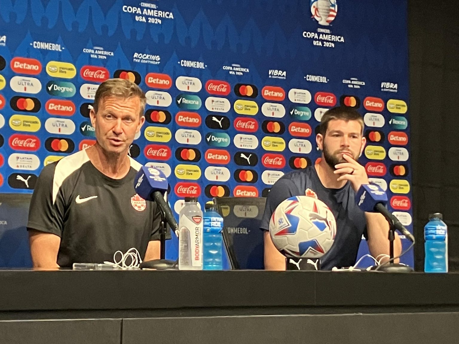 El seleccionador del equipo nacional masculino de fútbol de Canadá, Jesse Marsch (i), y el portero titular del equipo canadiense, Maxime Crépeau, fueron registrados el pasado 24 de junio, durante una rueda de prensa, en el estadio Children's Memorial Park de Kansas City (Misuri, EE.UU.). EFE/Albert Traver