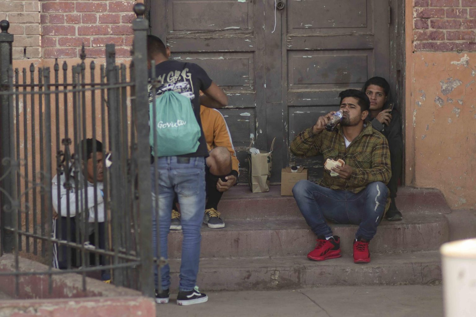 Migrantes comen en la entrada de un edificio en El Paso, Texas (EEUU). Imagen de archivo. EFE/Jonathan Fernández