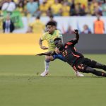 El defensa central colombiano Davinson Sánchez (d) fue registrado este martes, 2 de julio, al caer ante la marca del centrocampista brasileño Joao Gomes (c), durante el partido de cierre del grupo D de la Copa América 2024, en el Levi´s Stadium de Santa Clara (California, EE.UU.). EFE/John G.Mabanglo