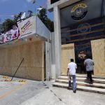 Trabajadores colocan tablas de madera para proteger un establecimiento por el paso del huracán Beryl, este miércoles en Cancún (México). EFE/Alonso Cupul