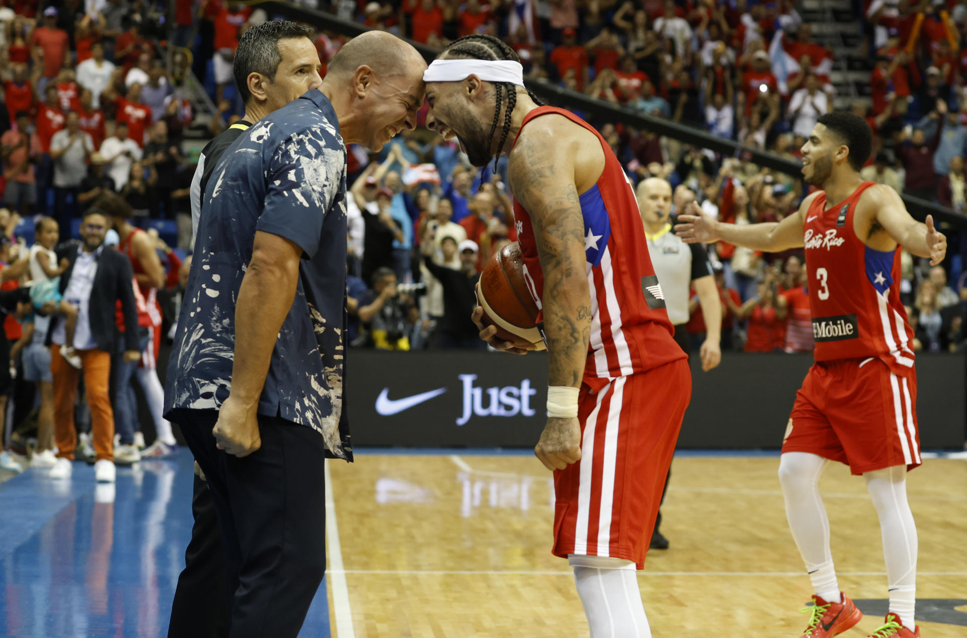 Los puertorriqueños Carlos Delgado (i) y José Alvarado celebran la obtención del cupo a los Juegos Olímpicos de París tras vencer este domingo a Lituania en la final del torneo clasificatorio disputado en el Coliseo José Miguel Agrelot, en San Juan. EFE/ Thais Llorca
