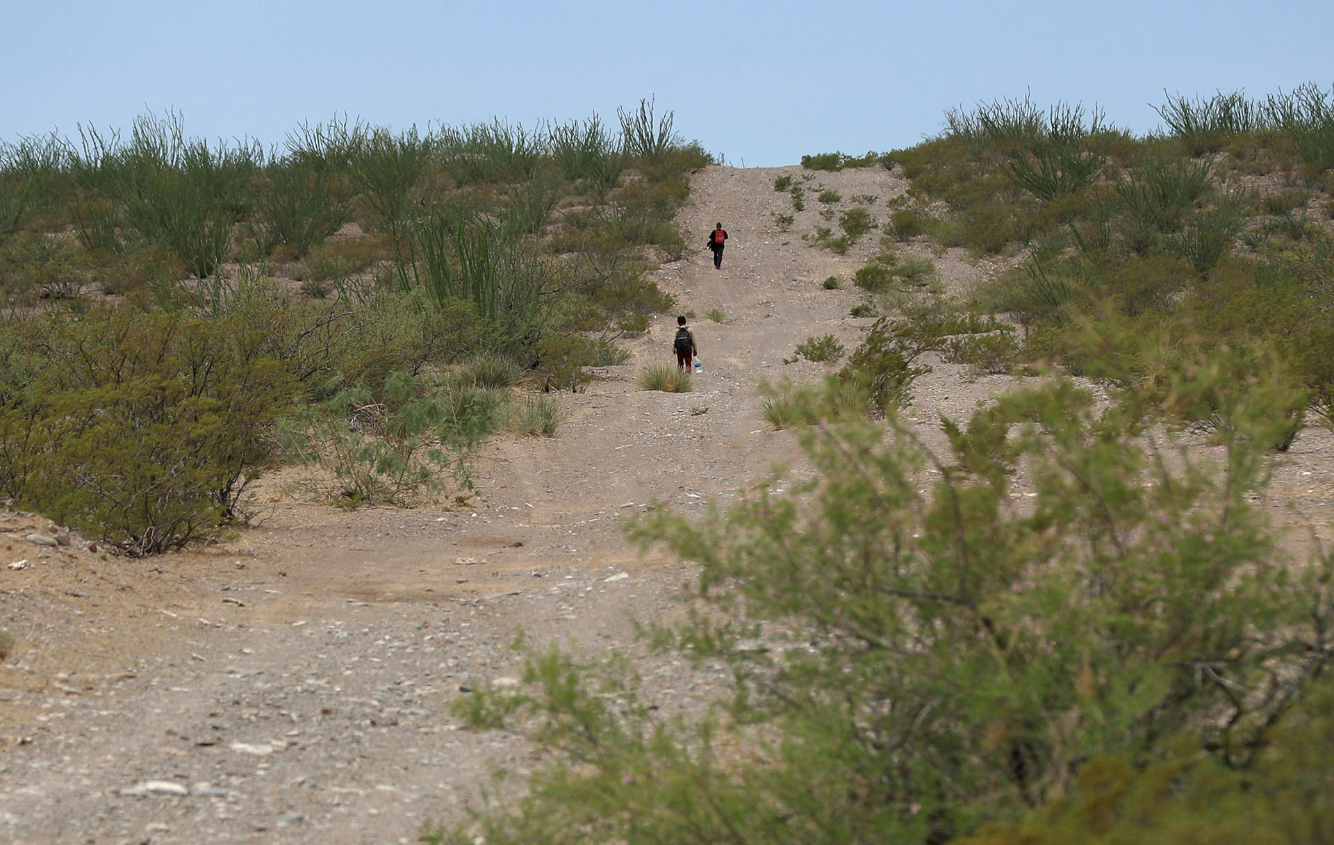 Migrantes caminan por las dunas del desierto de Chihuahua, el 5 de julio de 2024 en Ciudad Juárez (México). EFE/Luis Torres
