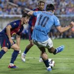 El centrocampista del Manchester City Jack Grealish (d) encara a tres rivales del Barcelona durante el partido amistoso de pretemporada jugado este martes en el Camping World Stadium de la ciudad estadounidense de Orlando (Florida). EFE/EPA/CRISTÓBAL HERRERA-ULASHKEVICH