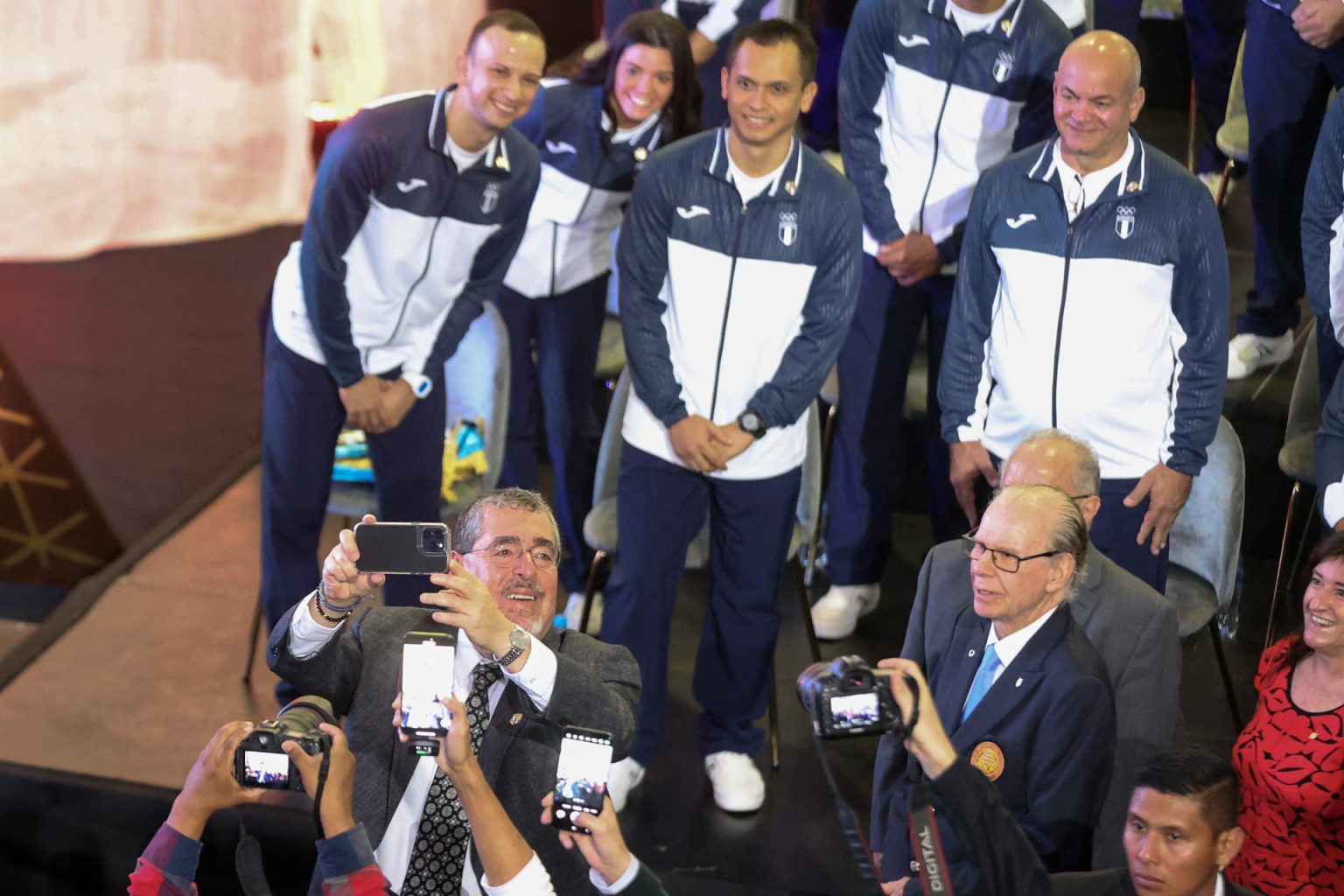 El presidente de Guatemala, Bernardo Arévalo de León (i-abajo), fue registrado este miércoles, 3 de julio, al tomarse una fotografía con la delegación de deportistas de su país que competirán en los Juegos Olímpicos de París 2024, en Ciudad de Guatemala (Guatemala).. EFE/ Fernando Ruiz