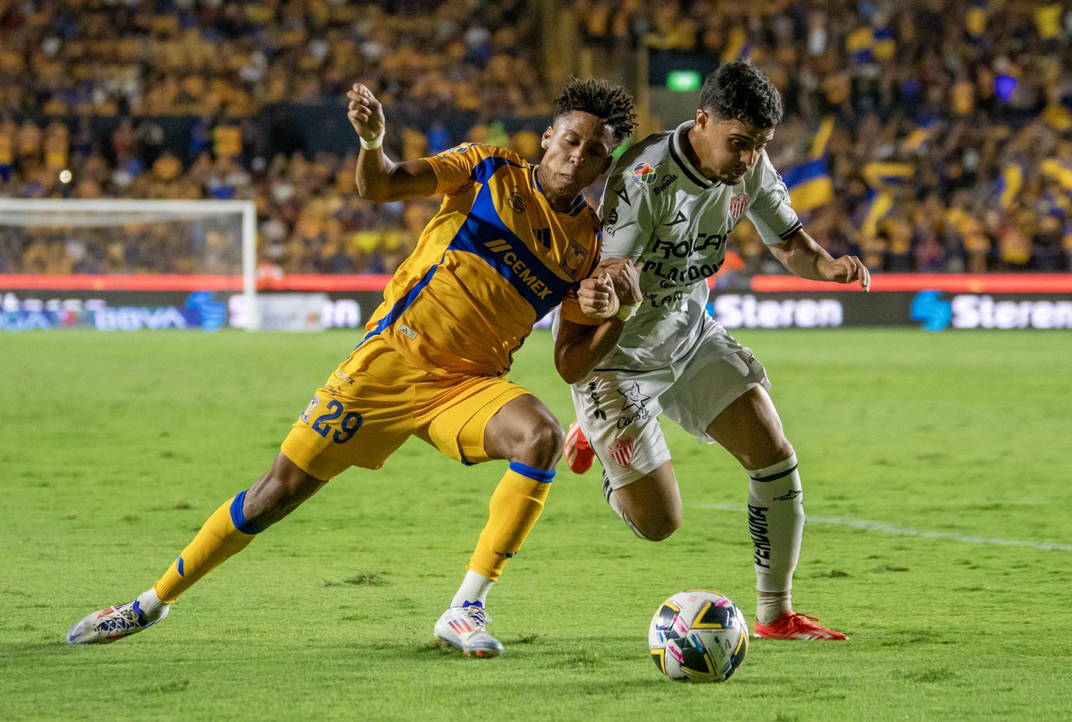 Ozziel Herrera (i) de Tigres disputa el balón con Agustin Oliveeros (d) de Necaxa durante un partido correspondiente a la jornada una del Torneo Apertura 2024. EFE/Miguel Sierra