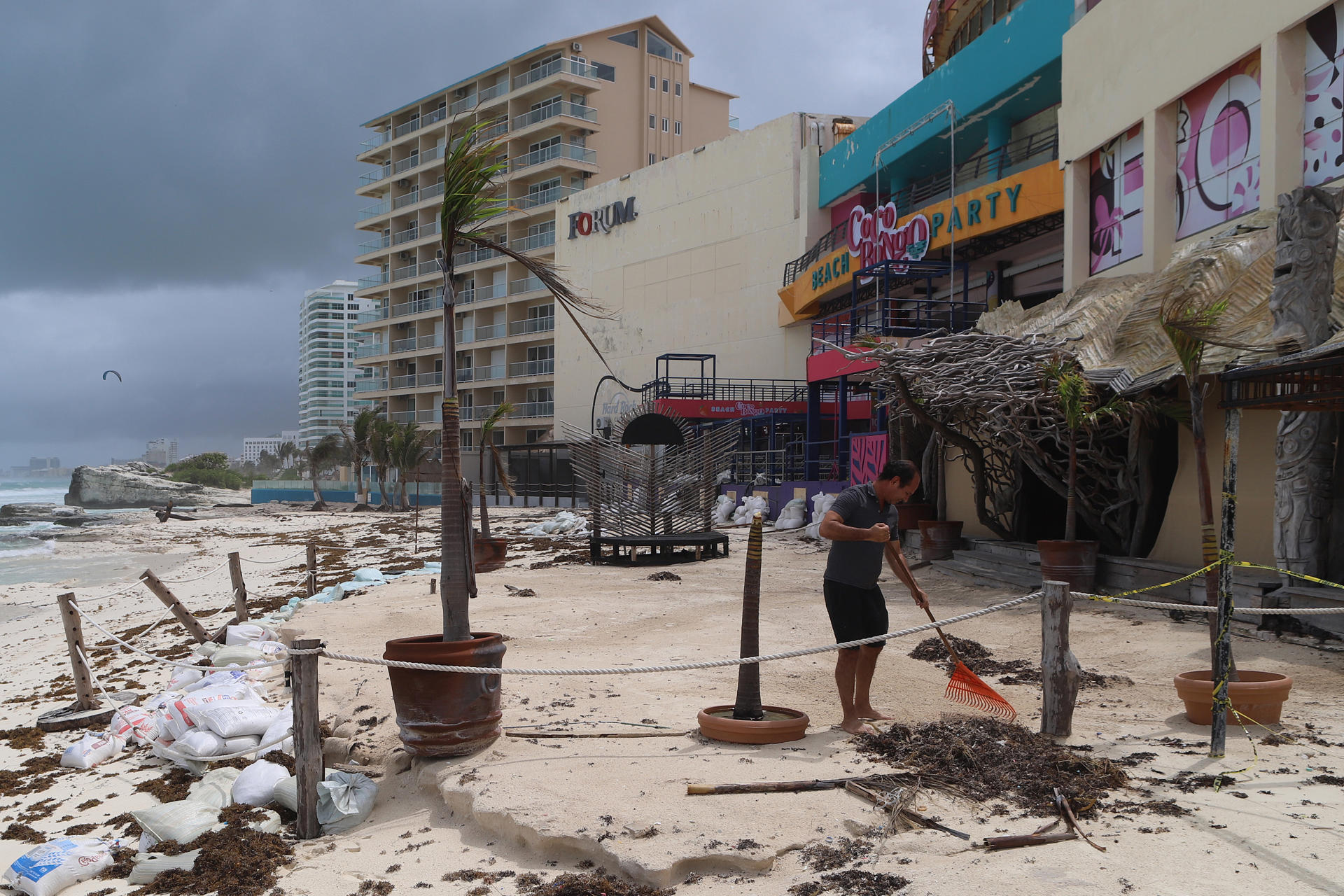 Fotografía donde se observa a personal limpiando sus negocios después del paso del huracán en las principales playas este viernes, en el balneario de Cancún en Quintana Roo (México). EFE/ Lourdes Cruz
