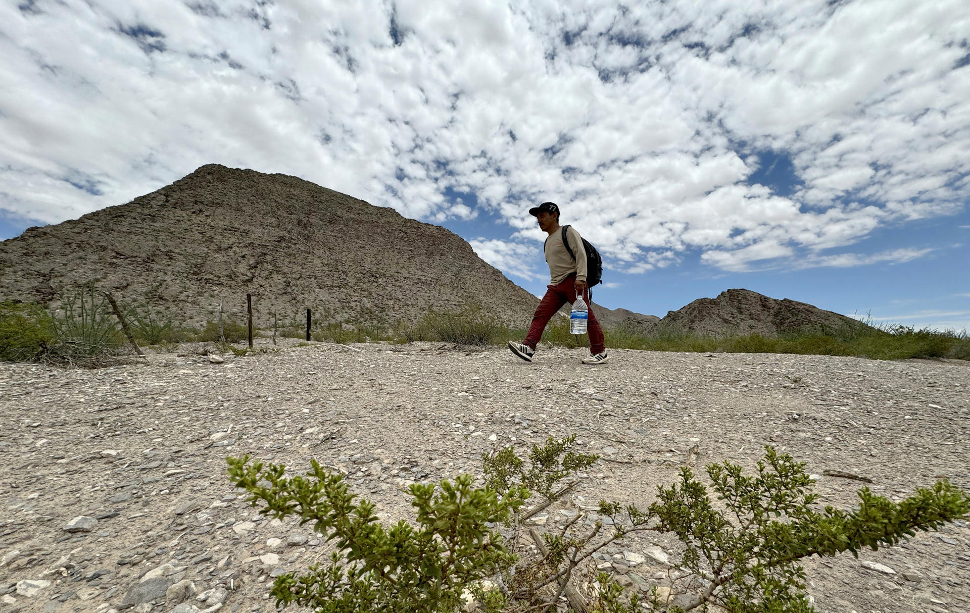 El migrante guatemalteco Jovany Ariza, camina por las dunas del desierto de Chihuahua, el 5 de julio de 2024 en Ciudad Juárez (México). EFE/Luis Torres
