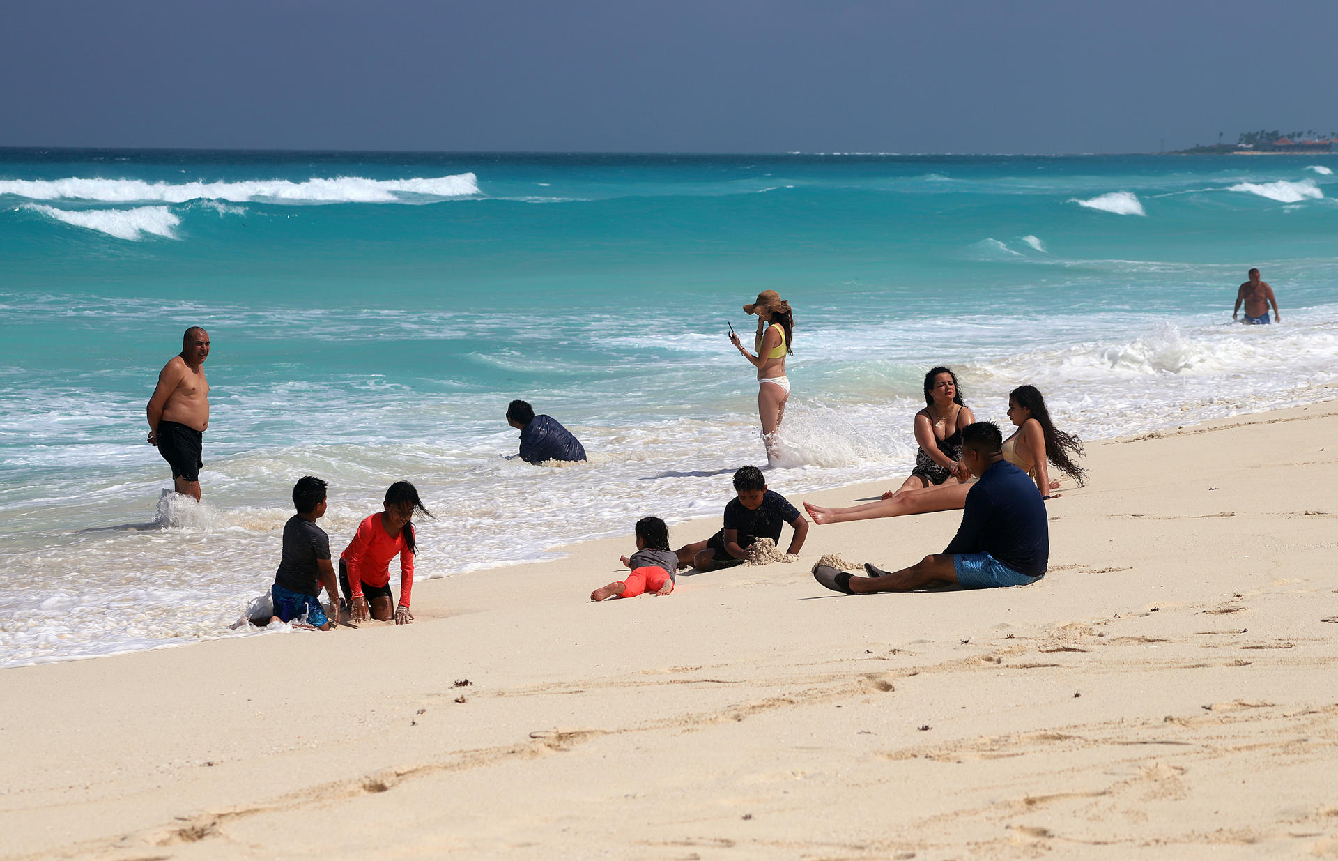 Turistas permanecen en las playas ante el alto oleaje este jueves, en el balneario de Cancún, en Quintana Roo (México). EFE/Lourdes Cruz
