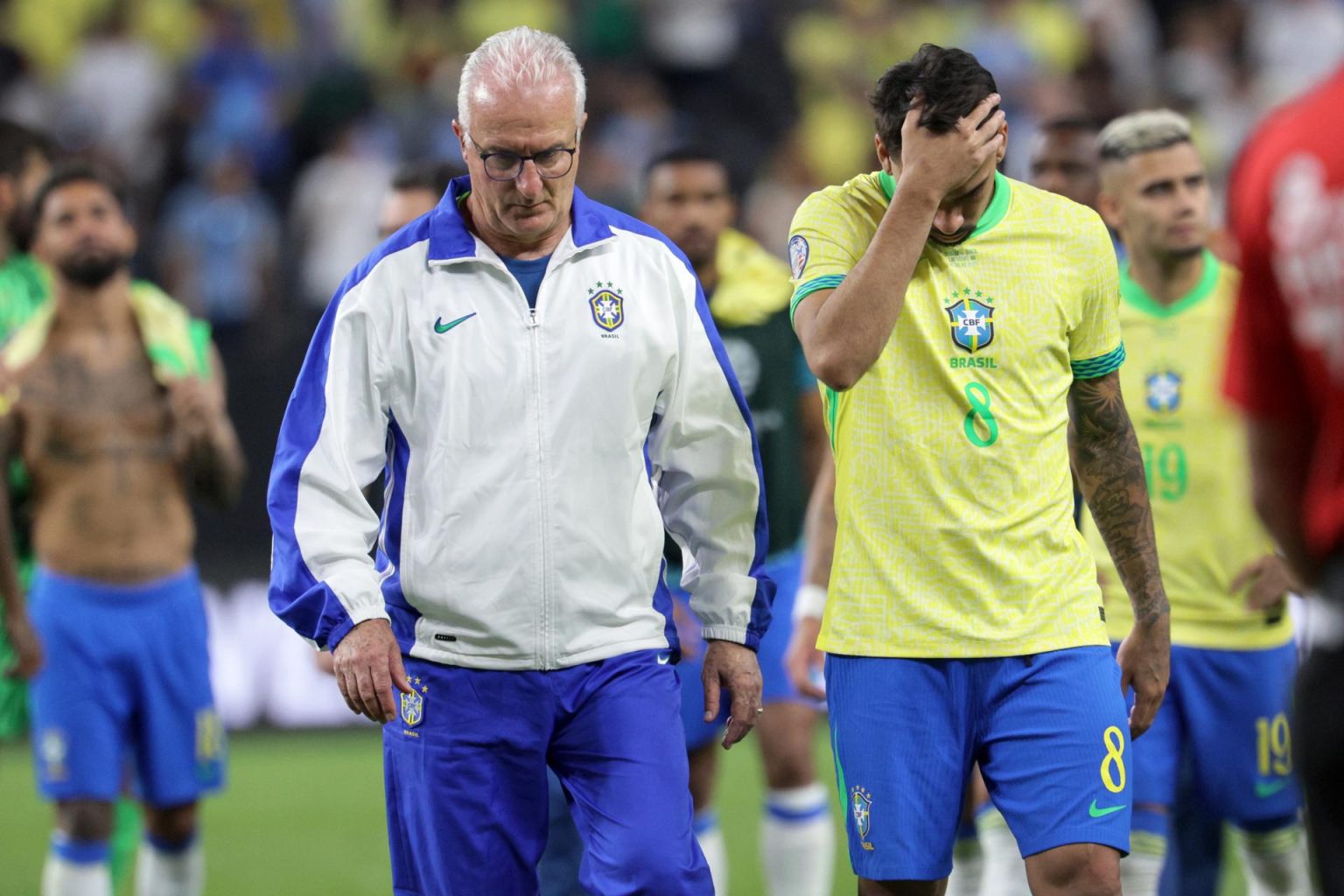 El entrenador de Brasil, Dorival Junior (I), sale del campo junto a Lucas Paquetá (D) de Brasil después de perder con Uruguay en la tanda de penaltis de los cuartos de final de la Copa América 2024 EFE/EPA/ALLISON DINNER