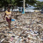 Una mujer camina por la playa Manresa, cubierta de basura tras el paso del huracán Beryl, este miércoles, en Santo Domingo (República Dominicana). EFE/ Orlando Barría
