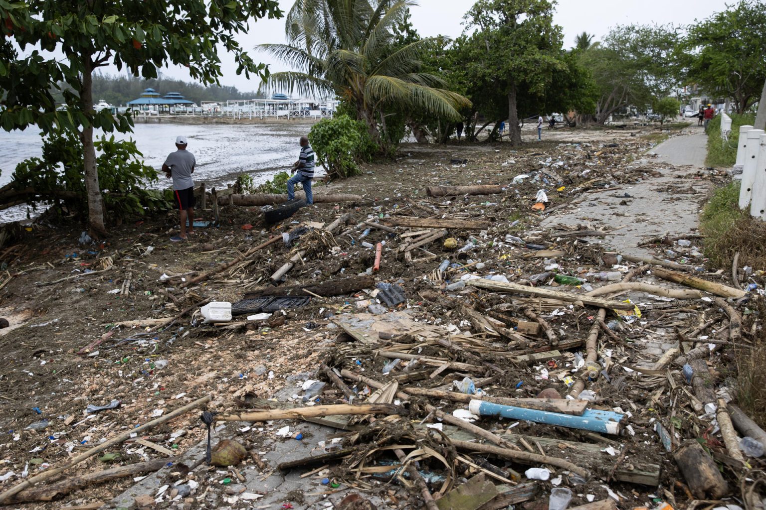 Hombres observan uno de los muelles destruidos en la Marina ZarPar, tras el paso del huracán Beryl, este miércoles, en Boca Chica (República Dominicana). EFE/ Orlando Barría