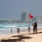 Turistas permanecen en las playas ante el alto oleaje este jueves, en el balneario de Cancún, en Quintana Roo (México). EFE/Lourdes Cruz