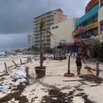 Fotografía donde se observa a personal limpiando sus negocios después del paso del huracán en las principales playas en el balneario de Cancún en Quintana Roo (México). EFE/Lourdes Cruz