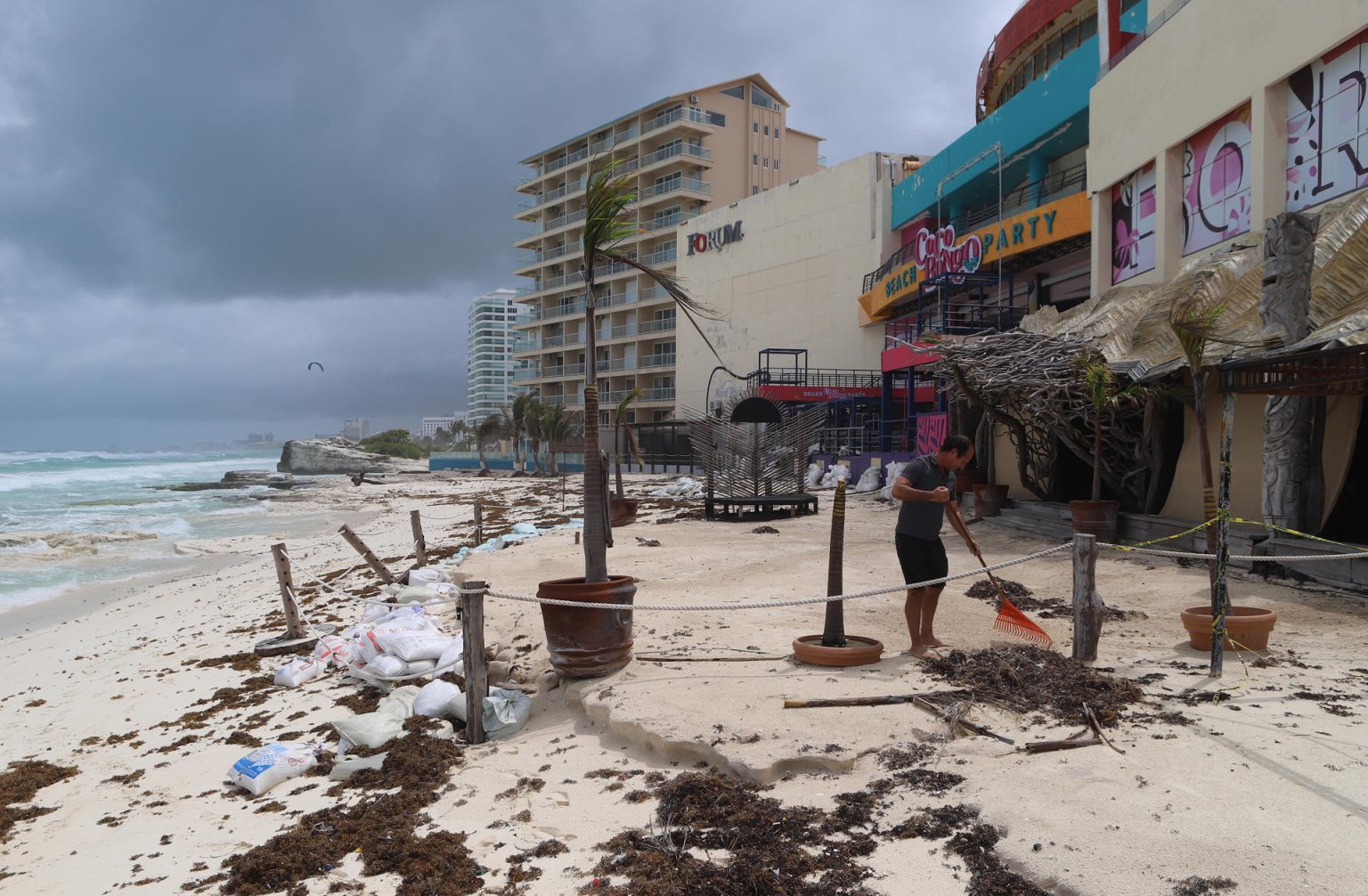 Fotografía donde se observa a personal limpiando sus negocios después del paso del huracán en las principales playas en el balneario de Cancún en Quintana Roo (México). EFE/Lourdes Cruz