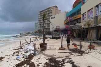 Fotografía donde se observa a personal limpiando sus negocios después del paso del huracán en las principales playas en el balneario de Cancún en Quintana Roo (México). EFE/Lourdes Cruz