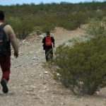 Migrantes caminan por las dunas del desierto de Chihuahua, el 5 de julio de 2024 en Ciudad Juárez (México). EFE/Luis Torres