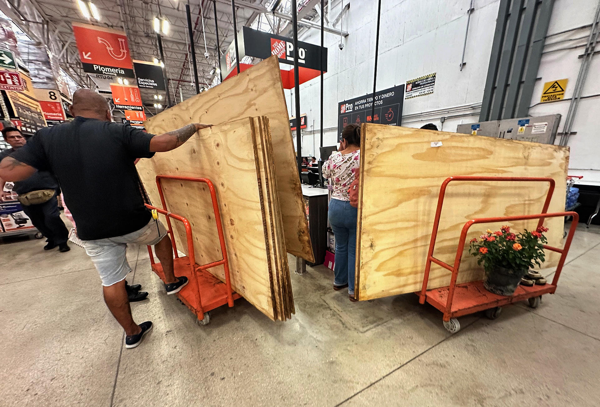 Personas compran tablas de madera para proteger fachadas, este miércoles en Cancún (México). EFE/Alonso Cupul
