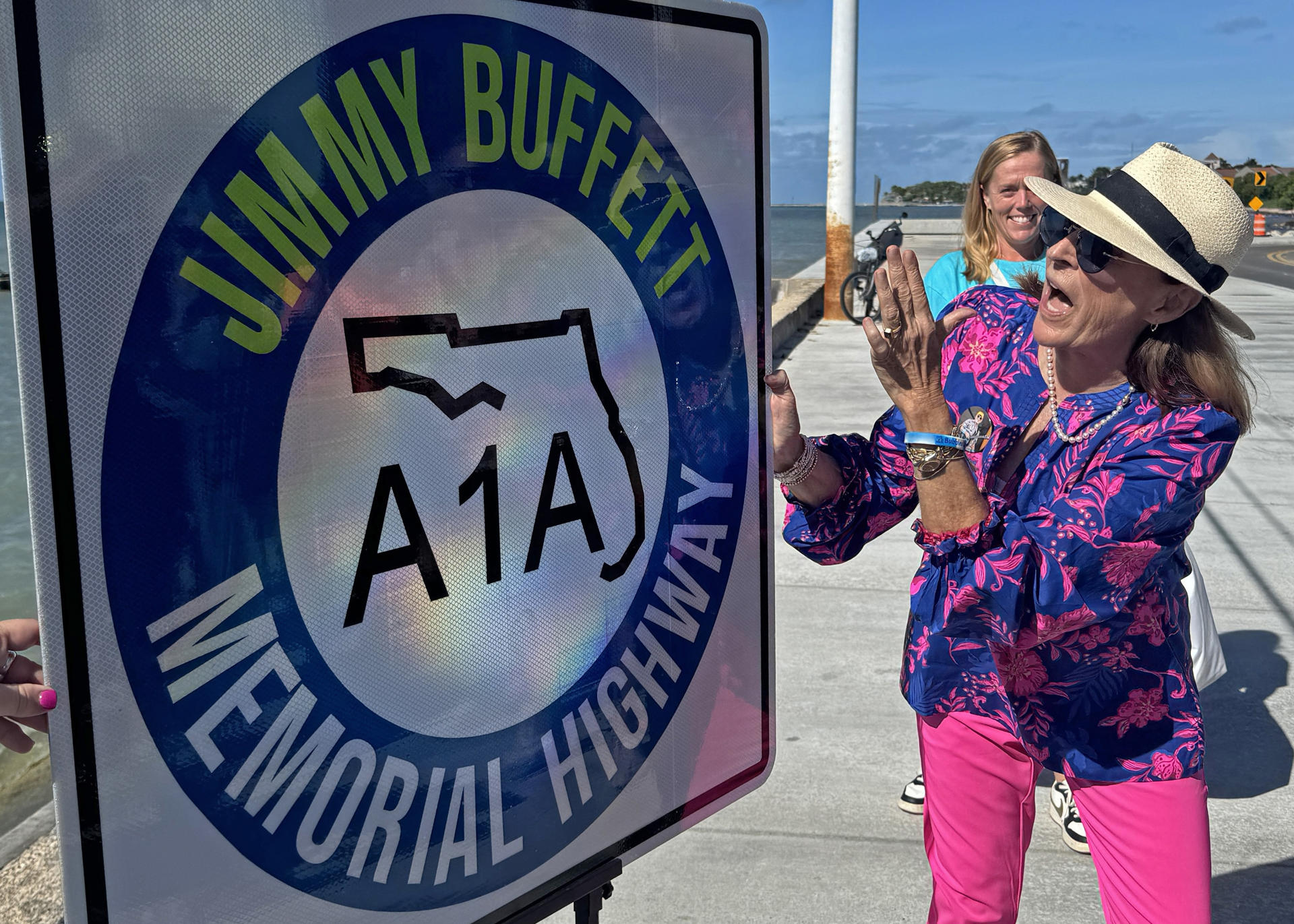 Fotografía cedida por la Oficina de Noticias de los Cayos de Florida donde aparece Lucy Buffett, hermana del fallecido cantautor Jimmy Buffett, mientras presenta el cartel de la autopista que designa la histórica State Road A1A como 'A1A Jimmy Buffett Memorial Highway', este viernes en Cayo Hueso (Estados Unidos). EFE/ Andy Newman / Oficina de Noticias de los Cayos de Florida / SOLO USO EDITORIAL/ SOLO DISPONIBLE PARA ILUSTRAR LA NOTICIA QUE ACOMPAÑA (CRÉDITO OBLIGATORIO)
