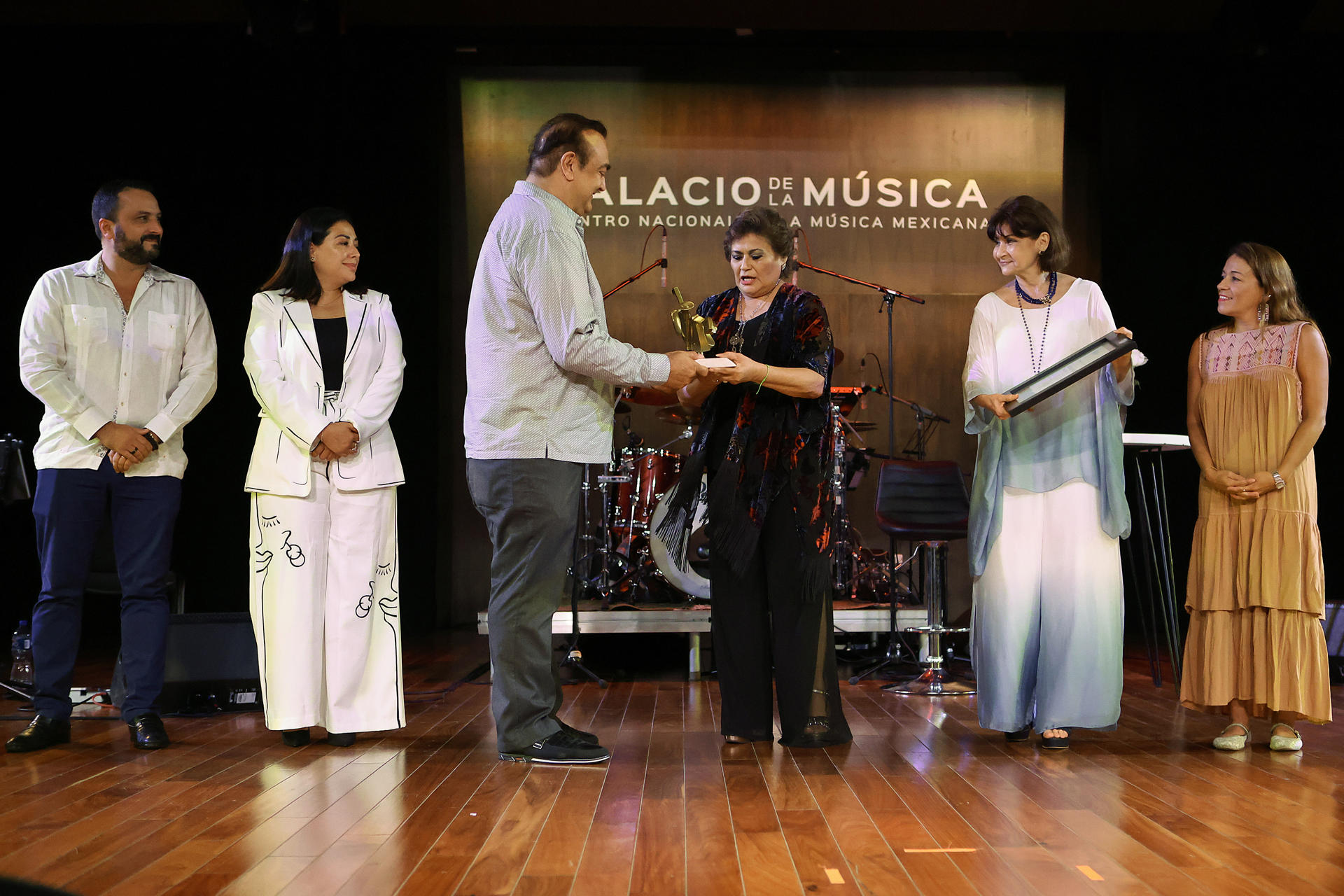 La cantante y compositora mexicana, María Medina (c-d), recibe un premio por el presidente del Consejo Consultivo del Palacio de la Música, Roberto Abraham Mafud (c-i), en la inauguración del Gran Festival del Palacio de la Música en la ciudad de Mérida en Yucatán (México). EFE/ Lorenzo Hernández
