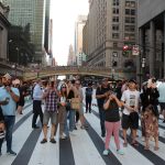 Un grupo de personas toman fotografías a la puesta del sol entre edificios en una calle de Manhattan en Nueva York (EEUU). Archivo. EFE/ Sarah Yáñez-Richards