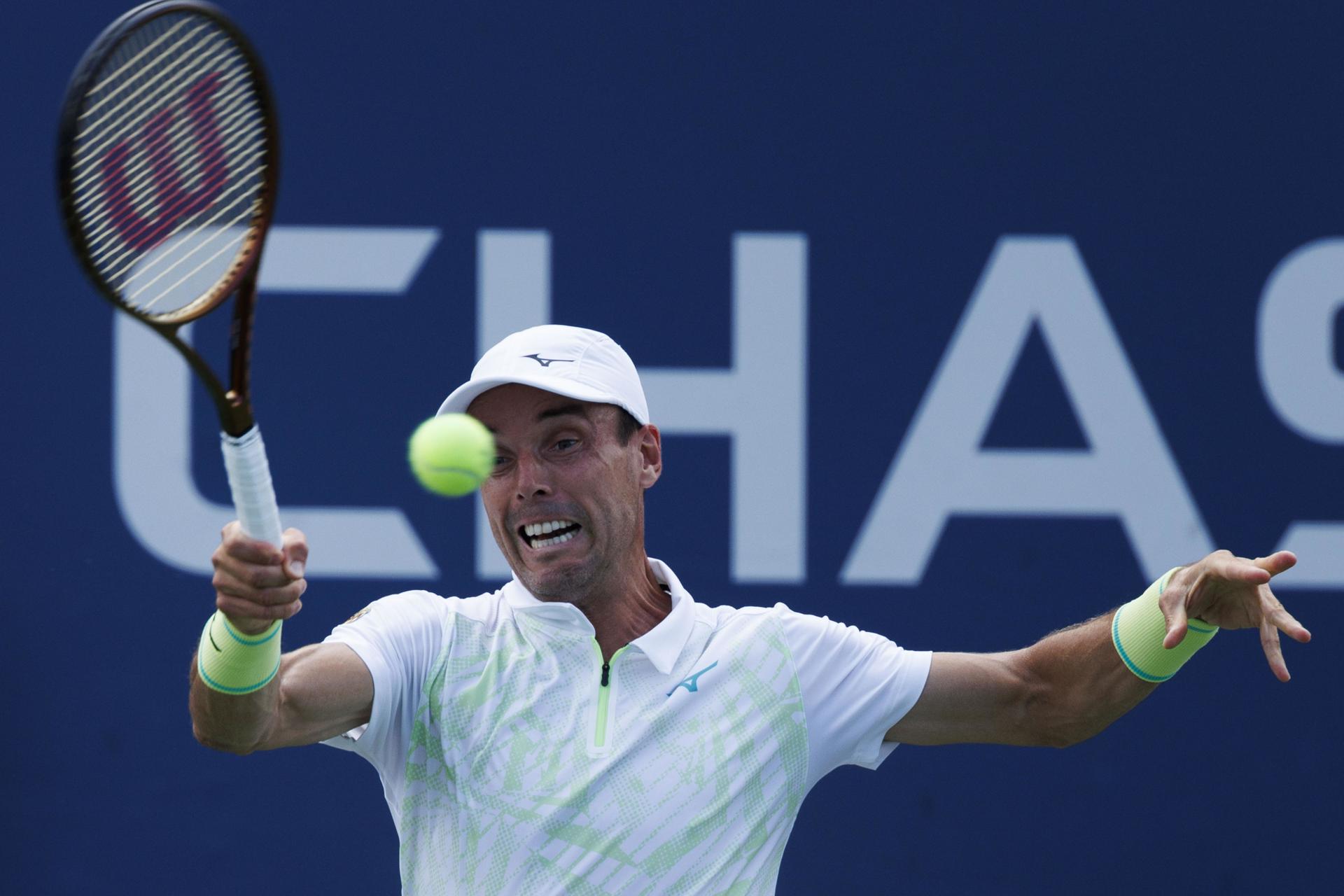 El tenista español Roberto Bautista fue registrado este lunes, 26 de agosto, al intentar devolverle una bola al italiano Luca Nardi, durante un partido de la primera ronda del Abierto de Estados Unidos, en el complejo USTA Billie Jean King National Tennis Center de Flushing Meadows (Nueva York, EE.UU.). EFE/CJ Gunther
