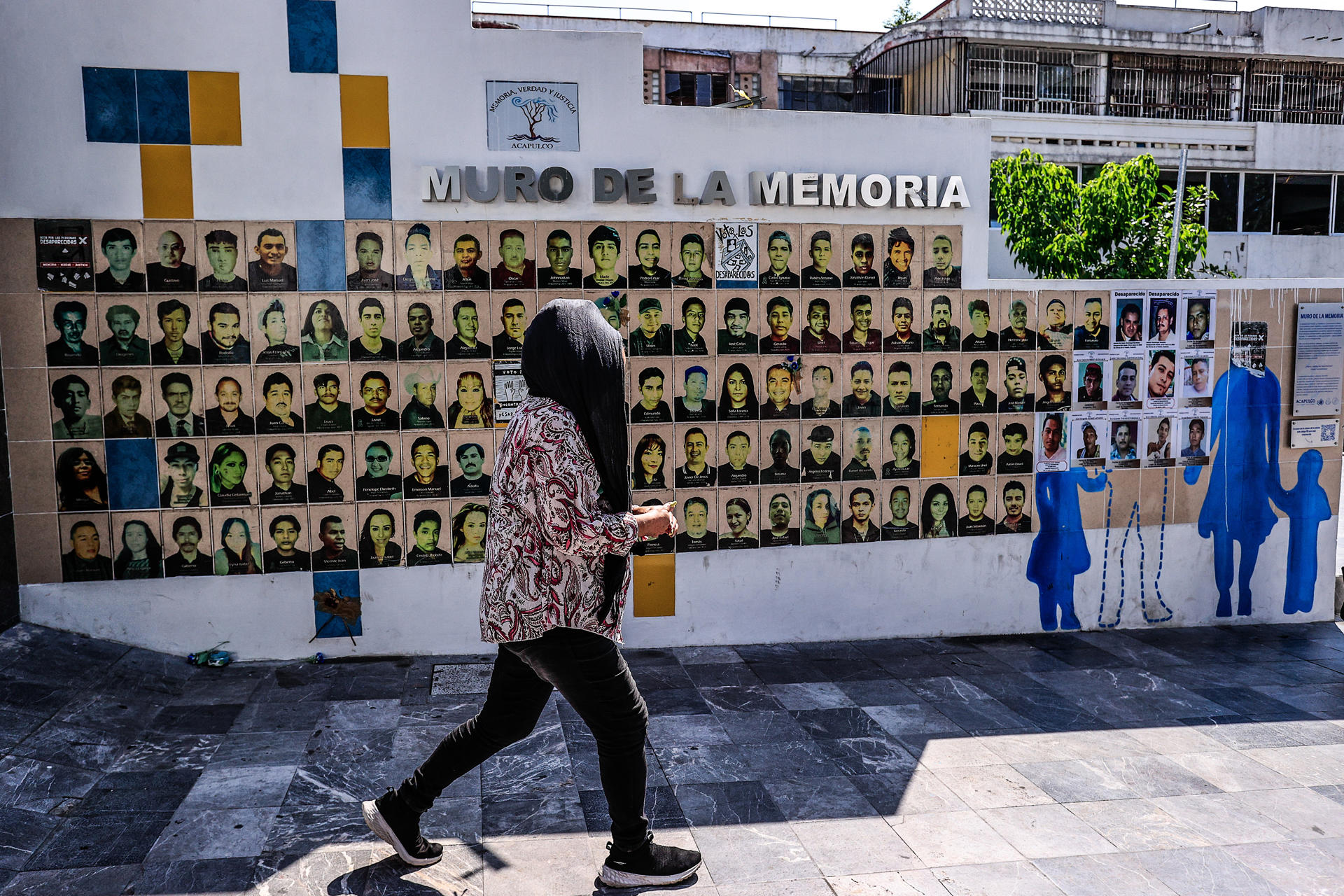 Una mujer pasa frente al 'Muro de la memoria' este jueves, en el balneario de Acapulco (México). EFE/David Guzmán
