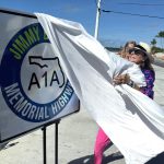 Fotografía cedida por la Oficina de Noticias de los Cayos de Florida donde aparece Lucy Buffett, hermana del fallecido cantautor Jimmy Buffett, mientras presenta el cartel de la autopista que designa la histórica State Road A1A como 'A1A Jimmy Buffett Memorial Highway', este viernes en Cayo Hueso (Estados Unidos). EFE/ Andy Newman / Oficina de Noticias de los Cayos de Florida / SOLO USO EDITORIAL/ SOLO DISPONIBLE PARA ILUSTRAR LA NOTICIA QUE ACOMPAÑA (CRÉDITO OBLIGATORIO)