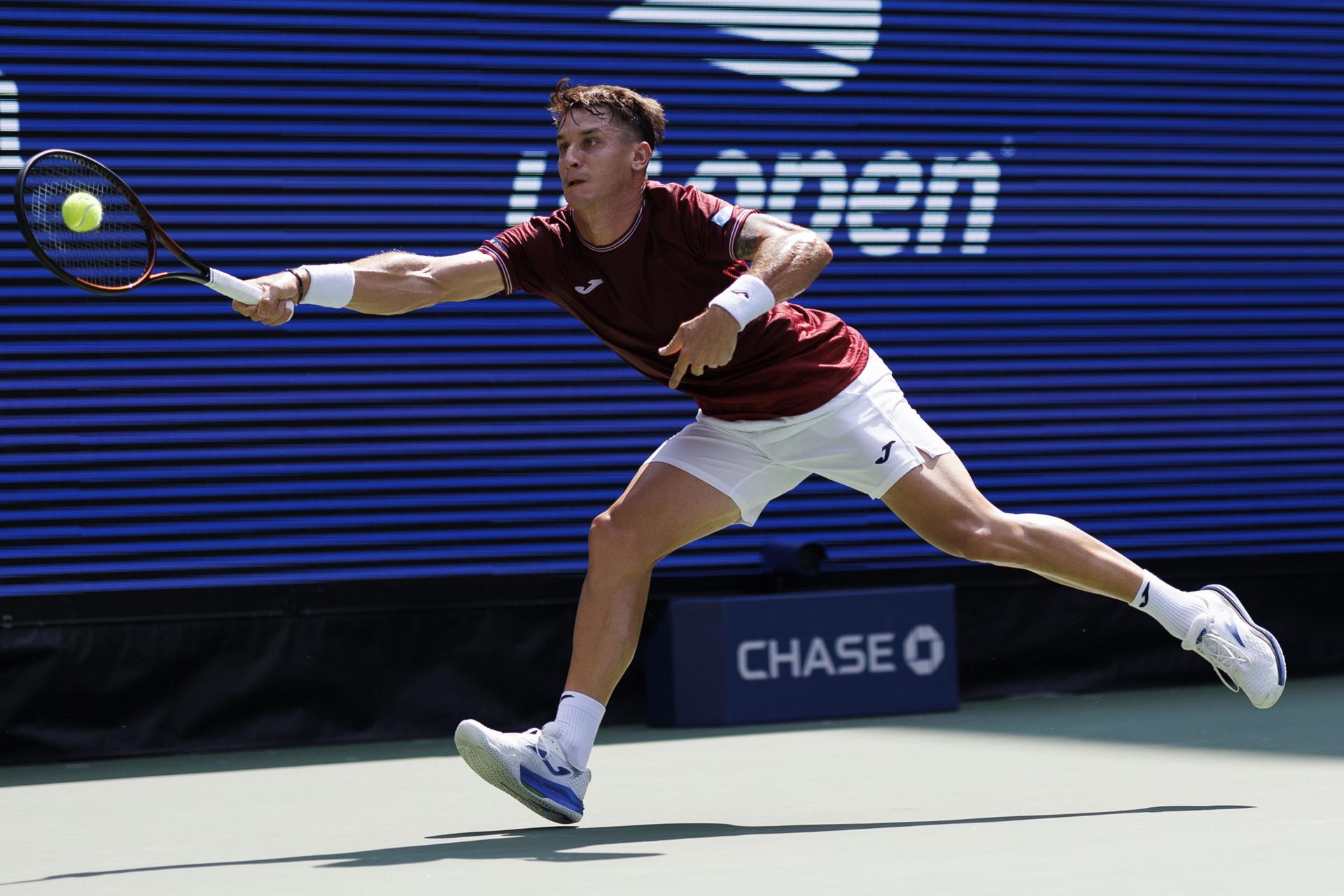 El tenista argentino Camilo Ugo Carabelli fue registrado este lunes, 26 de agosto, al intentar devolverle una bola al estadounidense Taylor Fritz, durante un partido de la primera ronda del Abierto de Estados Unidos, en el complejo USTA Billie Jean King National Tennis Center de Flushing Meadows (Nueva York, EE.UU.). EFE/CJ Gunther
