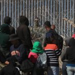 Migrantes esperan entre los alambres de púas mientras un agente estadounidense en Ciudad Juárez, Chihuahua (México). Imagen de archivo. EFE/Luis Torres