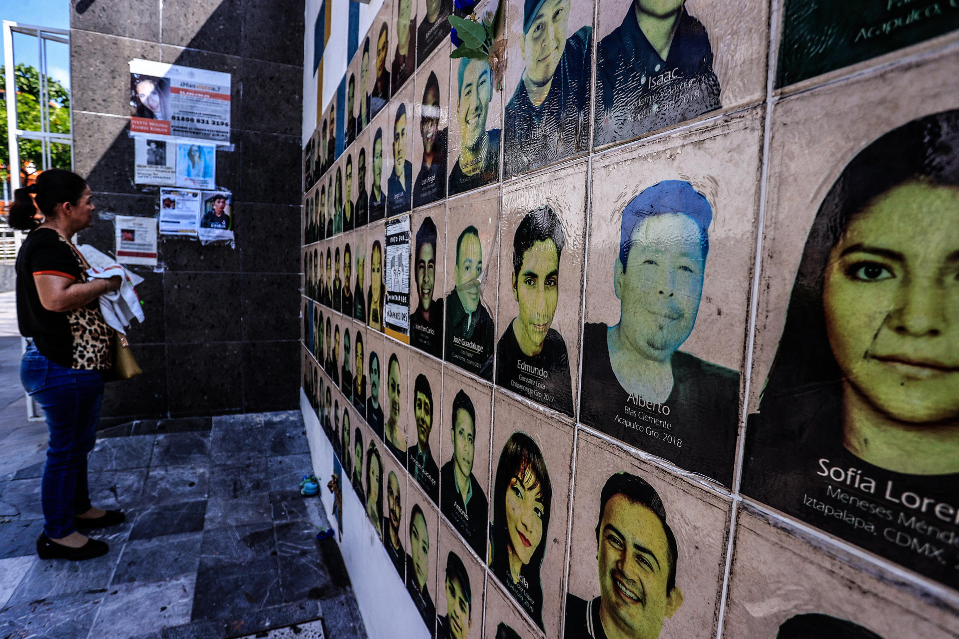 Una mujer observa de carteles de búsqueda de personas desaparecidas este jueves, en el balneario de Acapulco (México).EFE/David Guzmán
