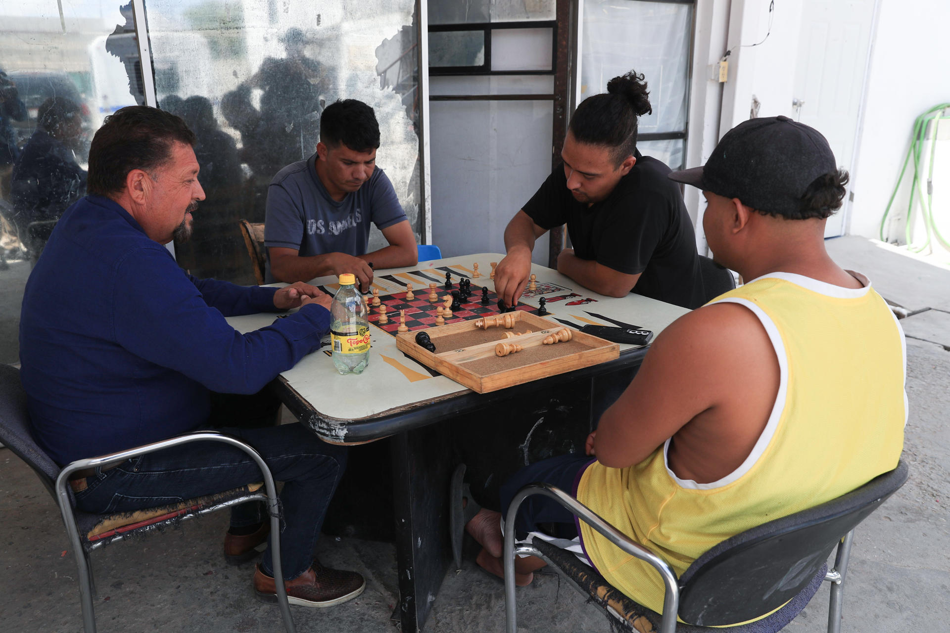 Migrantes juegan ajedrez en el albergue 'Tierra de Oro' en espera de resolver su situación migratoria este viernes, en ciudad Juárez (México). EFE/ Luis Torres
