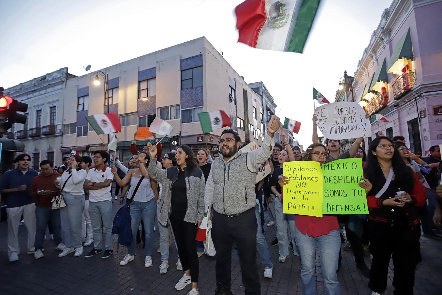 Personas se manifiestan a las afuera de las instalaciones del Congreso del Estado este miércoles, en la ciudad de Puebla (México). EFE/ Hilda Ríos