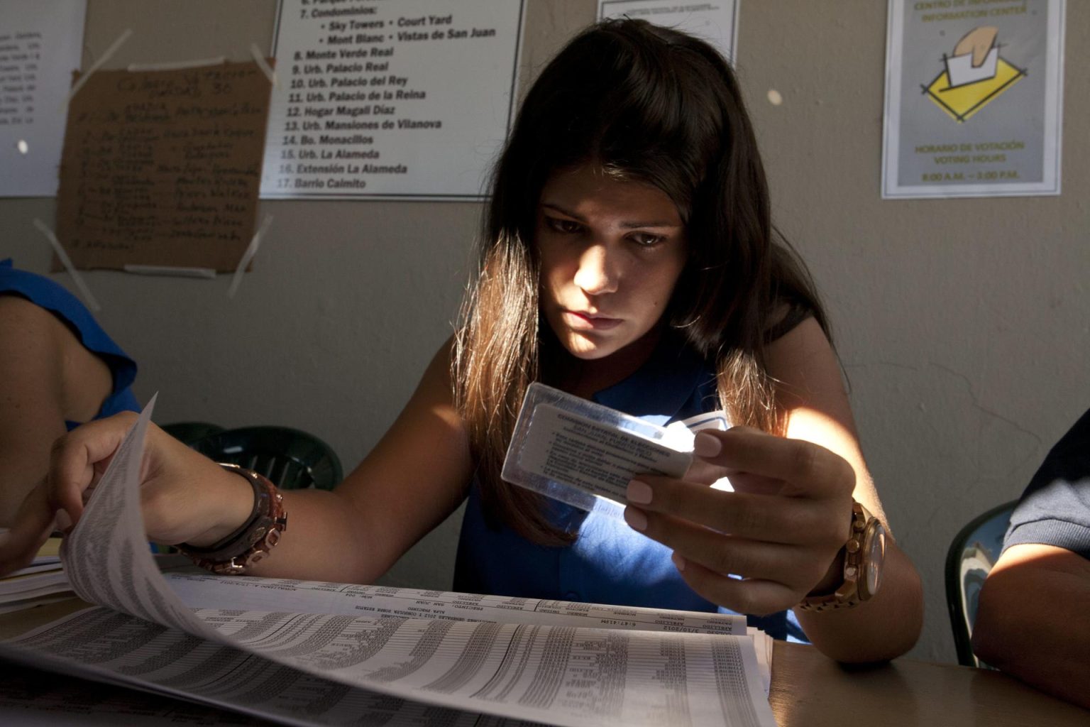 Imagen de archivo de una funcionaria de colegio electoral que busca a un votante en las listas electorales Puerto Rico. EFE/Thais Llorca