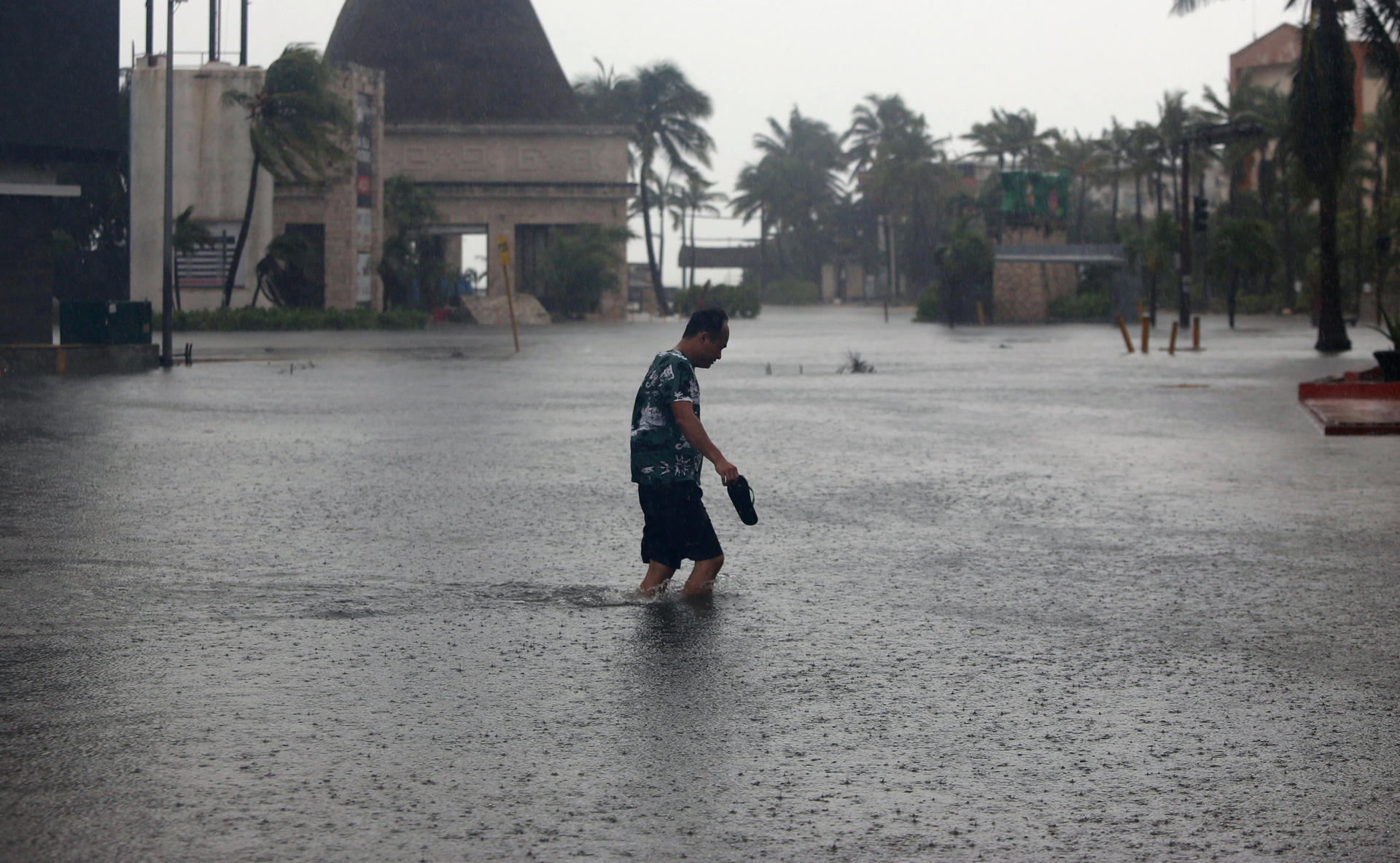 Una persona cruza una calle inundada tras el paso del huracán Helene, este miércoles en el balneario de Cancún, en Quintana Roo (México). EFE/Alonso Cupul
