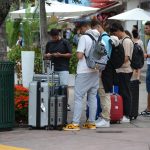 Un grupo de jóvenes turistas espera por un taxi junto a sus maletas el en la turística calle de Ocean Drive, en Miami Beach, Florida (EE.UU.). Imagen de archivo. EFE/ Antoni Belchi