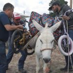 Personas cargan un burro con obsequios, alimentos y materiales educativos para llevarlos a indígenas rarámuris, el 13 de septiembre de 2024 en la comunidad de Guachochi de la sierra Tarahumara, estado de Chihuahua (México). EFE/Luis Torres