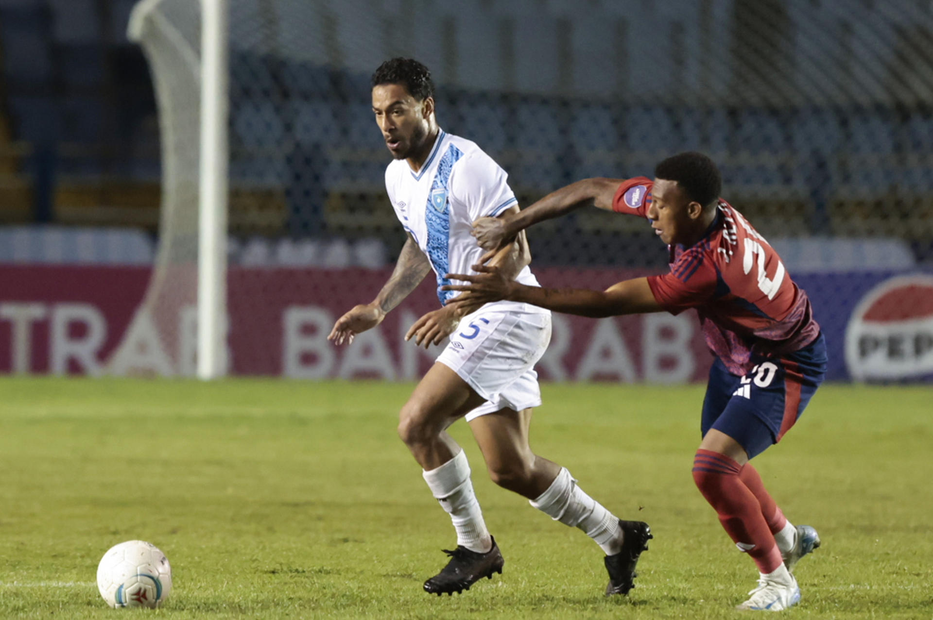 El guatemalteco Marco Domínguez (i) disputa un balón con el costarricense Josimar Alcócer durante el partido del grupo A de la Liga de Naciones de la Concacaf que ambas selecciones empataron 0-0 este lunes en el estadio Doroteo Guamuch Flores de Ciudad de Guatemala. EFE/ David Toro
